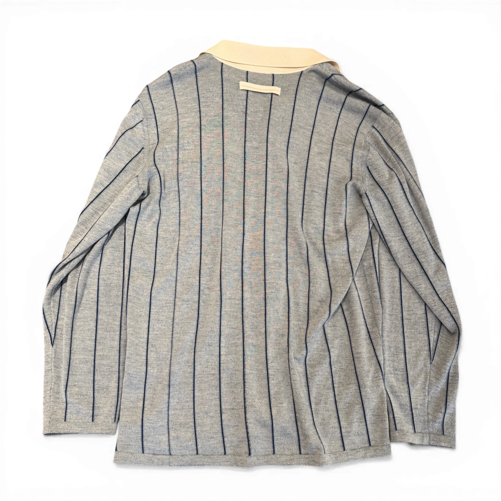 Ākaibu Store light grey cashmere shirt with navy vertical stripes and a cream collar. Features two chest pockets and button closure.