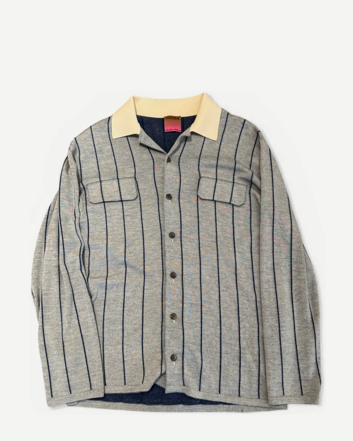 Ākaibu Store light grey cashmere shirt with navy vertical stripes and a cream collar. Features two chest pockets and button closure.