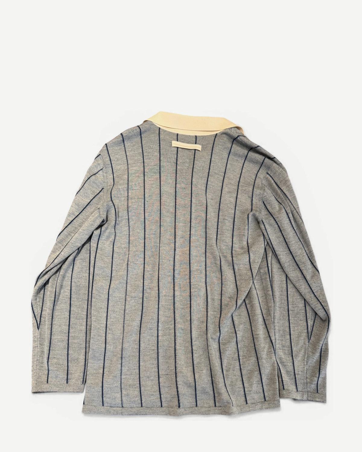 Ākaibu Store light grey cashmere shirt with navy vertical stripes and a cream collar. Features two chest pockets and button closure.